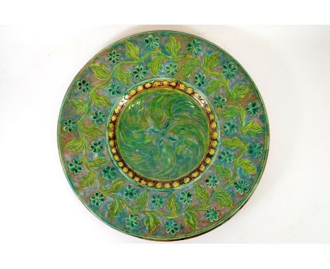 A large Della Robbia art pottery charger, decorated by Annie Jones and William Warwick, incised and slip continuous floral ba