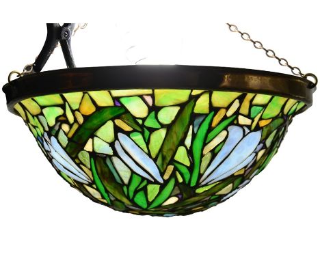 A Tiffany style pendant light, domed form with leaded glass lily design in opalescent, marbled and opaque tiles, suspended wi