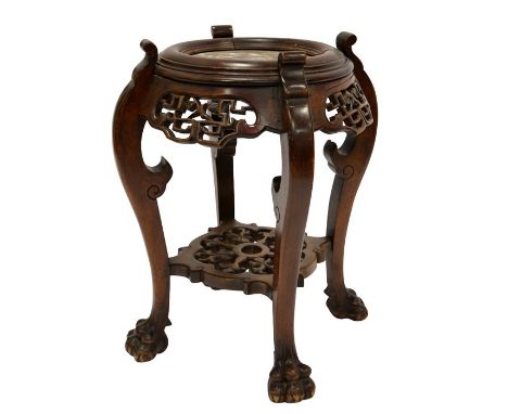 A Chinese hardwood jardinière stand, carved in relief and reticulated, the cabriole lions paw legs united by a pierced low sh