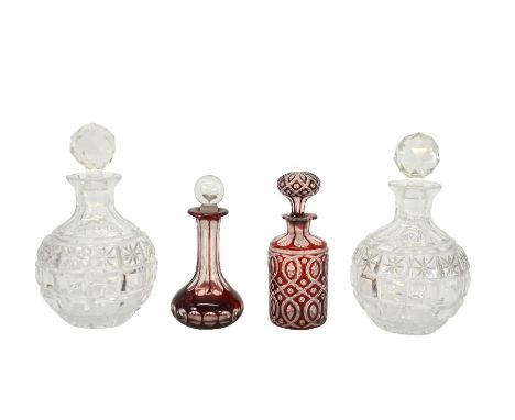 A pair of cut glass decanters, together with a ruby cased cut glass scent bottle and another, 18cm high (4)