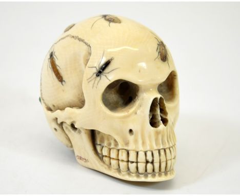 λ A 19th century Japanese Shibayama skull, Meiji, carved and applied with mother of pearl, abalone and horn insects, signed, 