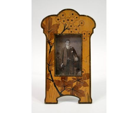 An Arts and Crafts marquetry photograph frame, circa 1900, in the Art Nouveau style, decorated with a flowering plant inlaid 