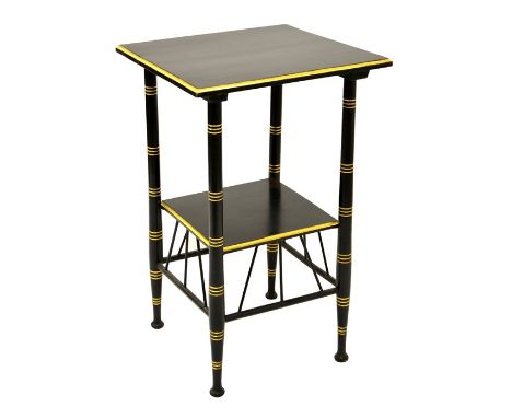 After E W Godwin, an ebonised coffee or occasional table, circa 1875, with gilt banding, the lower shelf supported on Thebes 