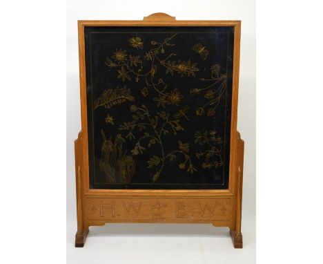 A Cotswold School carved oak firescreen, the lower frieze with initials HW EW and oak leaf motif,  84cm high, 63cm wide