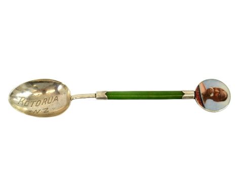 A New Zealand Arts and Crafts silver, jade and enamelled teaspoon, the stem of apple green stone, with native Mauri portrait 