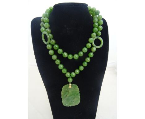 A jade necklace with carved pendant and gold clasp