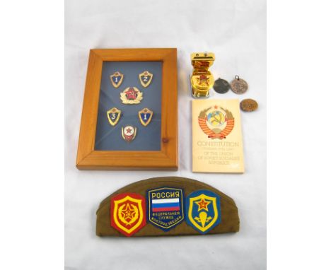 Russian Militaria. A Soviet gas cigarette lighter and ash tray shaped as a toilet, a forage cap with fabric and metal badges,