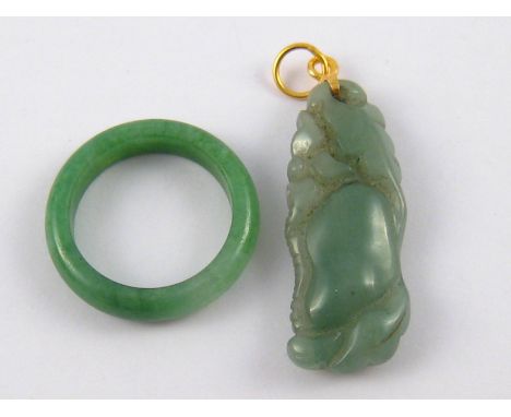 A Chinese carved jade pendant with yellow metal fitting, marked 585, 4cm, together with a jade ring.
