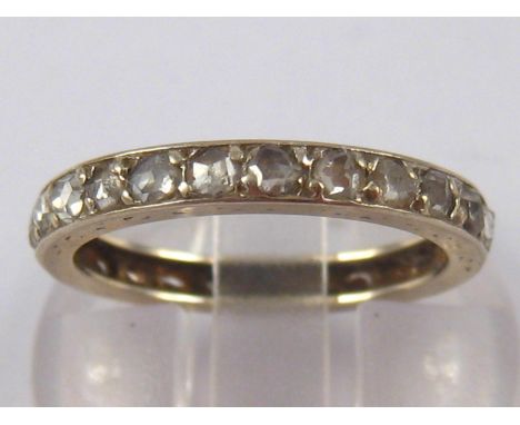 A white metal (tests 18 carat gold) rose cut diamond eternity ring, approx 2.8mm wide, ring size K ½, 1.9 gms.
