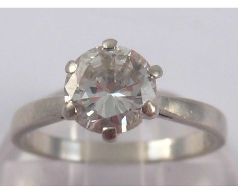 A white metal (tests platinum) diamond solitaire ring, the round brilliant cut diamond of good colour measuring approx 6.6mm 