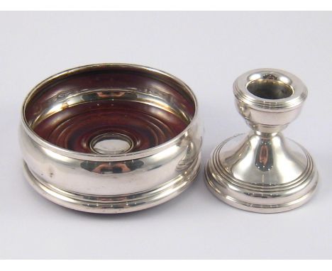Hallmarked silver. A bottle coaster with display hallmarks, London 1998., and a dwarf candlestick, Birmingham, 1977. 
