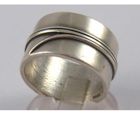A silver ring, approx 12.5mm wide, maker's mark FT, ring size R, 12.8 gms.
