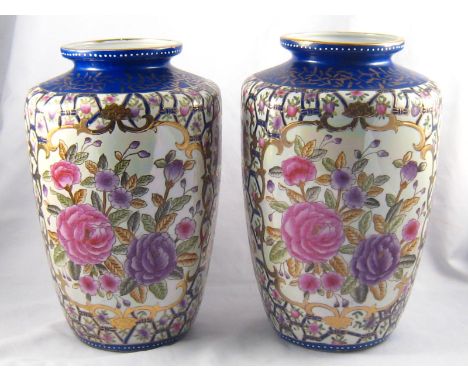 A pair of Chinese ceramic vases with panels of flowers in blue mesh and gilt  framing. ht. 30cm.