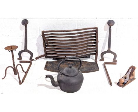 A pair of cast iron fire dogs with grate, firedog height 49cm, grate width 63cm, along with a cast iron pot, candle stand and