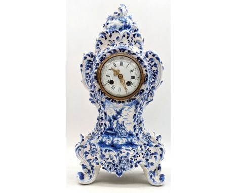 An ornate blue and white porcelain mantel clock, delftware style with hand painted decoration and a Maple & co clock mechanis