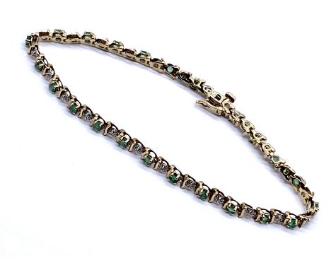 A 9ct emerald set tennis bracelet with diamond accents. 22cm length 6.8g total weight