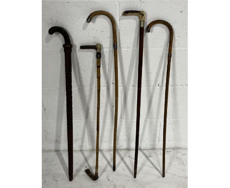 A collection of walking sticks along with a riding crop and a swagger stick, some silver mounted