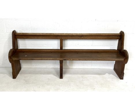 An antique pitch pine church pew with shaped ends and open back - length 188cm