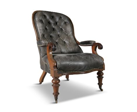 A WILLIAM IV MAHOGANY FRAMED BUTTON BACK LIBRARY CHAIR, upholstered in close nailed faded brown leather, with padded arm rest