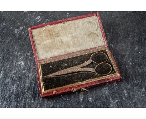 A pair of gilt needlework scissors, chased with flowers, in red Moroccan fitted case, together with a barrel bobbin holder, o