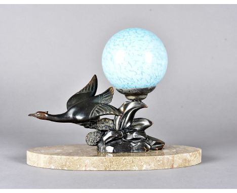 An art deco spelter table lamp, modelled as a flying sea bird on a rock formation signed Limousin having a spherical blue gla