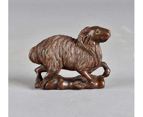 A Japanese hardwood netsuke, carved as a ram, black glass eyes, signed to base, 5.5 cm 
