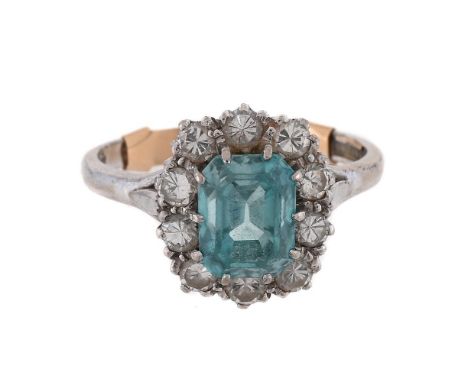 
	
		BRAVINGTONS, A BLUE ZIRCON AND DIAMOND CLUSTER RING 
		LONDON 1977 
		The step cut blue zircon with canted corners, with