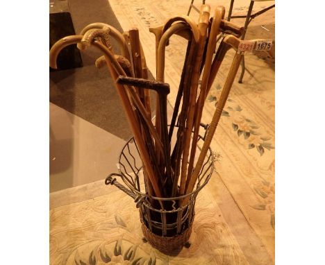 Collection of walking sticks with a wicker and metal stick stand 