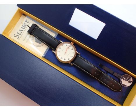 Boxed Stauer gents quartz wristwatch with gold plated steel case and leather strap with dial displaying Roman chapters and da