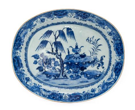 A Chinese Porcelain Meat Platter, Qianlong, of oval form, painted in underglaze blue with objects on rockwork flanked by pine