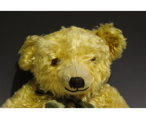 A Merrythought mohair teddy bear with large flat ears, amber and black eyes, stitched snout and jointed body with fabric pads