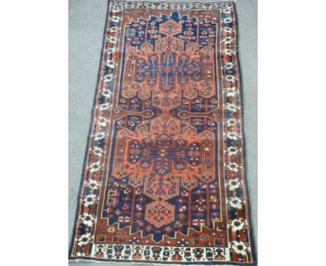 Persian Baktihari long carpet, with two cruciform medallions,  over blue ground geometric floral design and boarder, 310cm x 