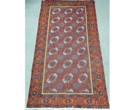 Afghan long carpet with three rows of seven guls, over red ground triple floral boarders, 328cm x 167cm Condition Report Clic