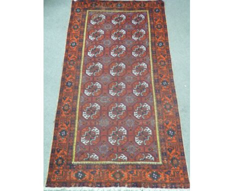 Afghan long carpet with three rows of seven guls, over red ground triple floral boarders, 328cm x 167cm Condition Report Clic