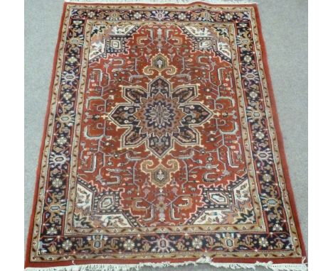 Heriz Indo Persian carpet, with central rosette over red ground, floral design, spandrels, triple boarder, 245cm x 174cm Cond