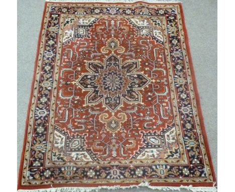 Heriz Indo Persian carpet, with central rosette over red ground, floral design, spandrels, triple boarder, 245cm x 174cm Cond