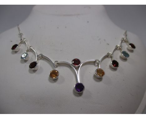 A multi-gemset necklace, the ten gemstones comprising of amethyst, garnet, citrine, and topaz all in rubover settings on arch