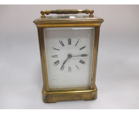A brass cased carriage clock with white dial and black numerals, cased with key  