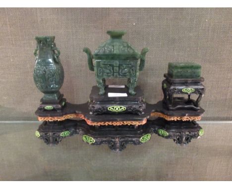 A Chinese spinach green jade censer, vase and incense box on a three tiered wood stand, Qianlong marks  