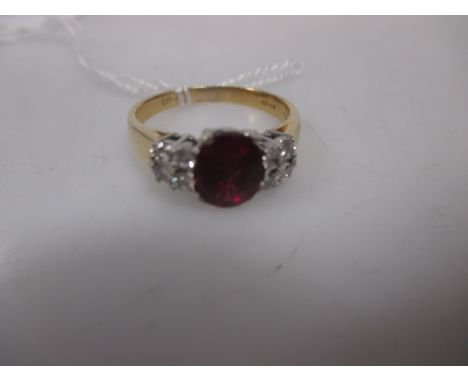 A ruby and diamond ring, the oval ruby measuring 7.9 x 6.9 x 3.5mm (not tested) in a four claw mount and set to either side w