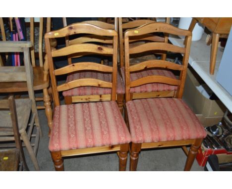 A set of four pine ladder back dining chairs