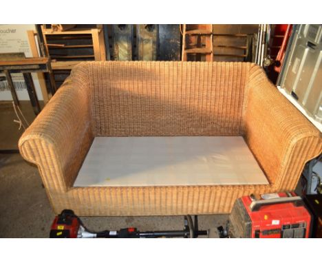 A wicker conservatory sofa, lacking cushion 