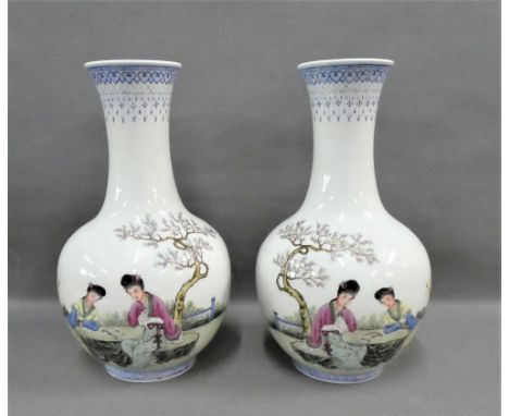 Pair of Chinese white glazed vases painted with figures in a garden with blue and white stylised borders and calligraphy, wit