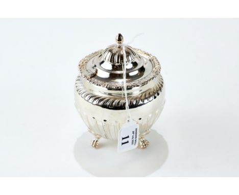 AN EDWARDIAN SILVER TEA CADDY of half fluted circular form raised on paw feet, maker: Kemp Bros, Birmingham 1904, approx 199 