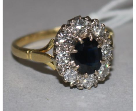 An 18ct gold, sapphire and diamond set oval cluster ring, size R.