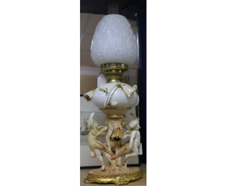 A Moore Bros white, cream and gilt porcelain oil lamp with cherub and flowering cactus support, with foliate-moulded opaque w