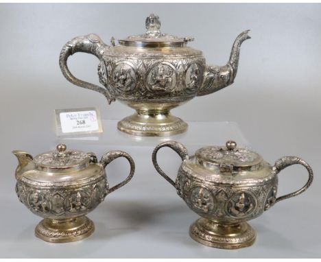 Indian white metal three piece teaset comprising:  teapot, two handled lidded sucrier and a lidded cream jug, all decorated w