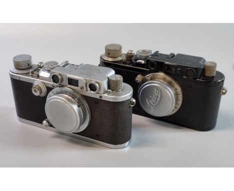 Two Leica viewfinder roll film cameras, both with F50mm Leitz Elmar standard lenses, one having black body No. 74736, the oth