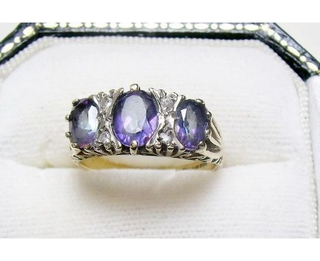 A 9 carat gold ring set three tanzanites and four chip diamonds 