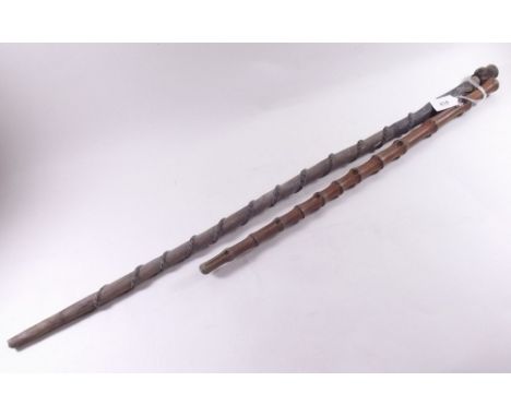 A bamboo effect swagger stick and an African carved stick